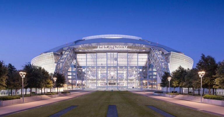 A massive, glowing exterior shot of the stadium to instantly hook the reader and establish the scale of the World Cup venue.